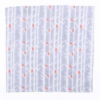 Cloth with white tree pattern and orange accents on a light blue background