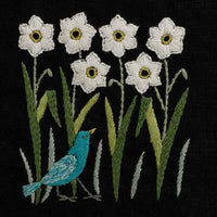 Embroidered design of white flowers and a blue bird on a black background