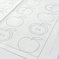 White fabric with apple-shaped outlines on a white background