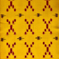 Textile with red and black pattern on a yellow background
