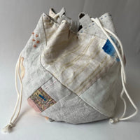 Drawstring bag with patchwork design on a light gray background