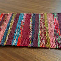 Multicolored woven mat on a wooden surface