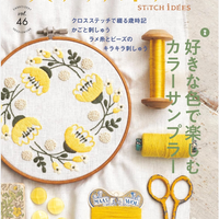 Embroidery book cover with cross-stitch design, yarn, scissors, and decorative elements.