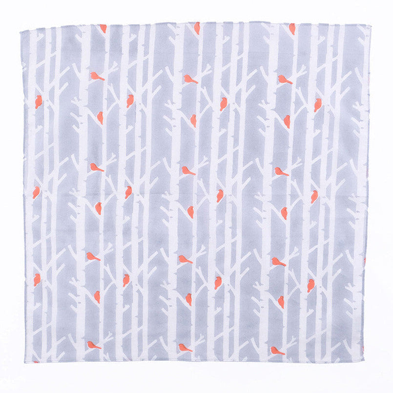 Cloth with white tree pattern and orange accents on a light blue background