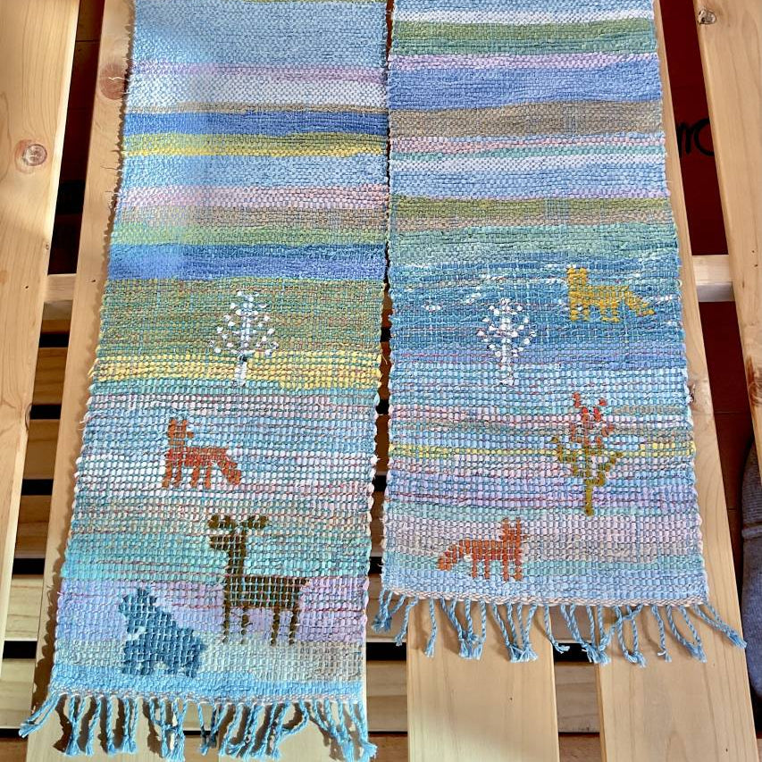 Woven scarf with animal designs on a wooden background