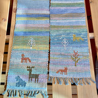 Woven scarf with animal designs on a wooden background