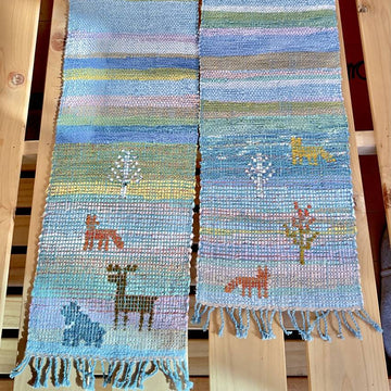 Woven scarf with animal designs on a wooden background