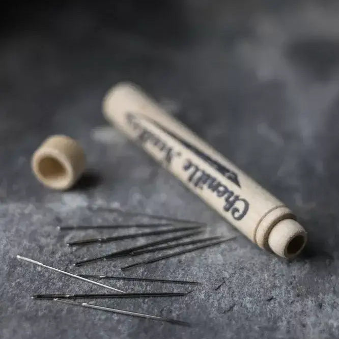 Needle tube and needles on a textured dark surface