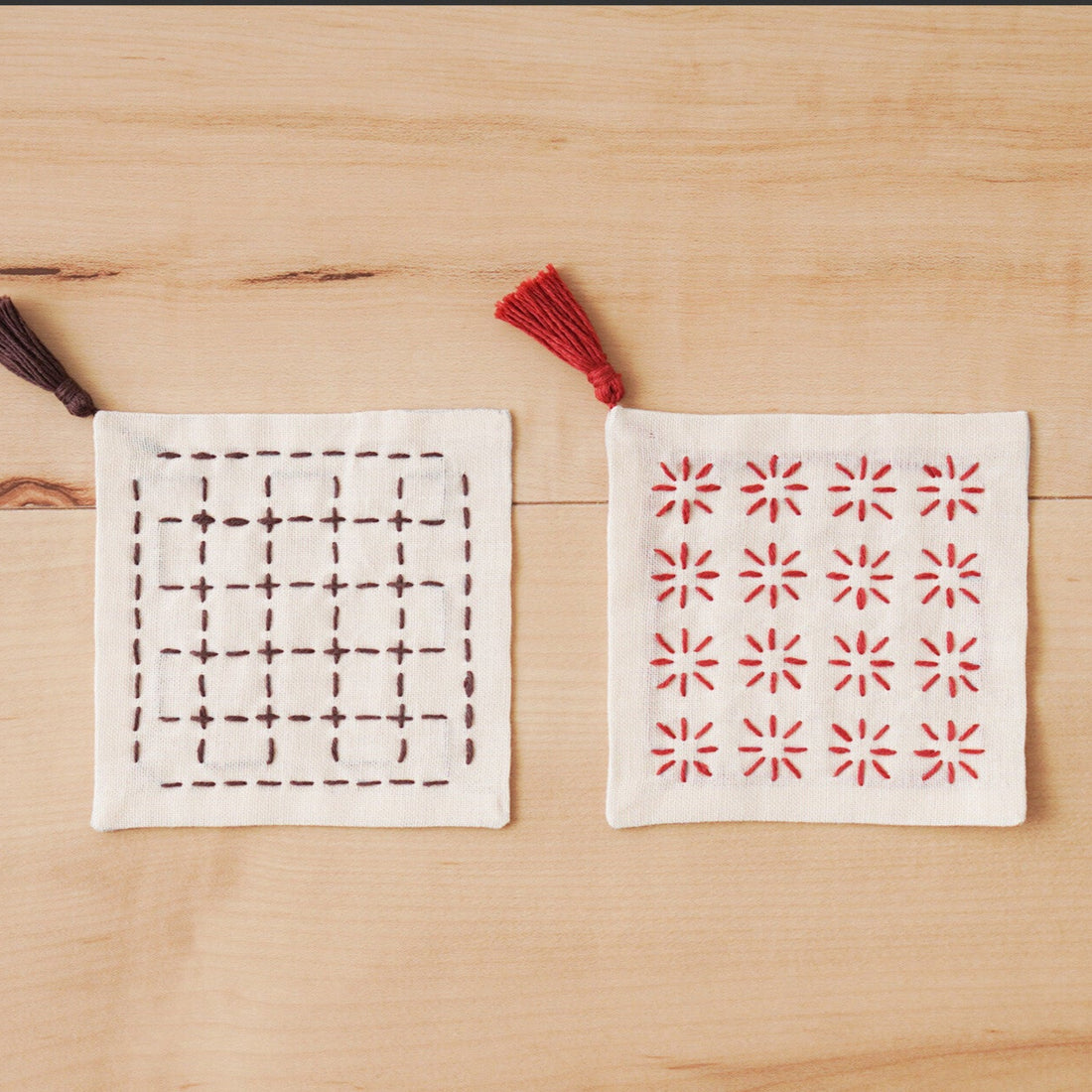 Two fabric coasters with different patterns on a wooden surface