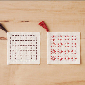 Two fabric coasters with different patterns on a wooden surface