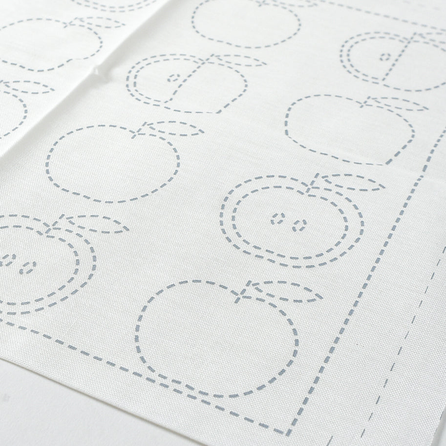 White fabric with apple-shaped outlines on a white background