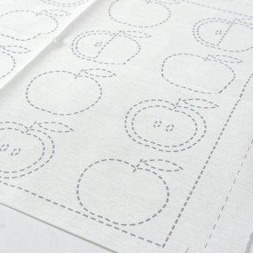 White fabric with apple-shaped outlines on a white background