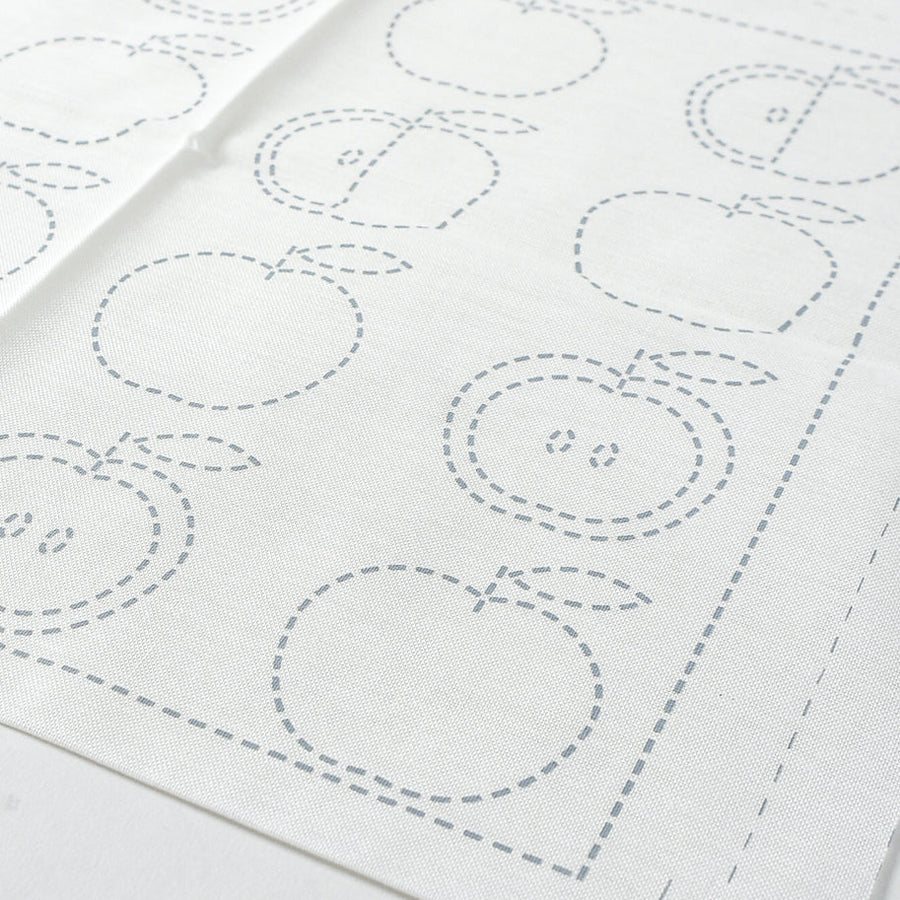 White fabric with apple-shaped outlines on a white background