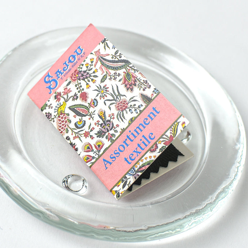 Packaged needles with floral design and text on a clear glass plate