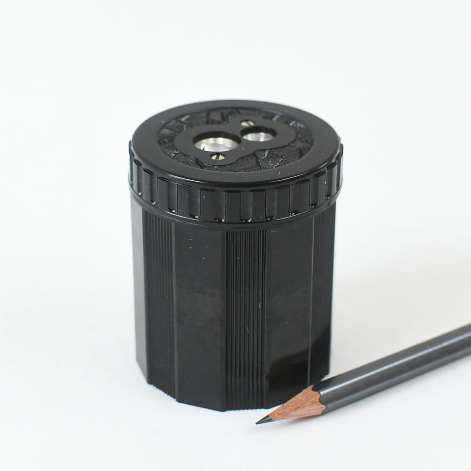 Black pencil sharpener with a pencil on a white background