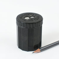 Black pencil sharpener with a pencil on a white background