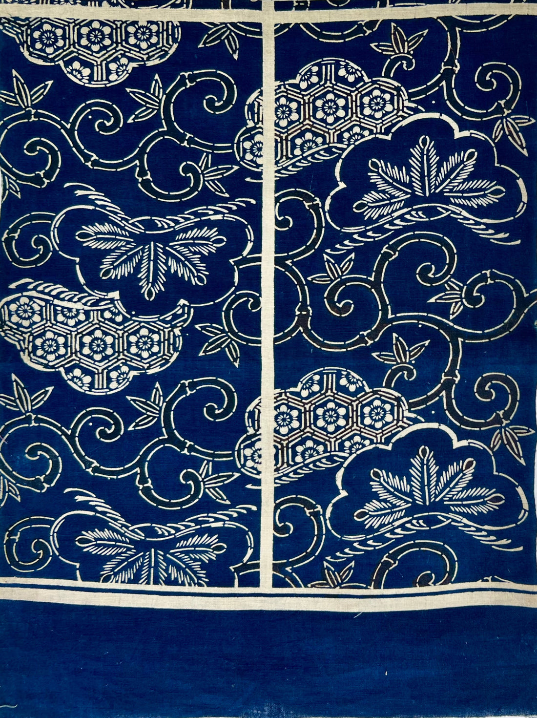 Blue fabric with white floral and geometric patterns on a white background