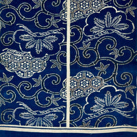 Blue fabric with white floral and geometric patterns on a white background