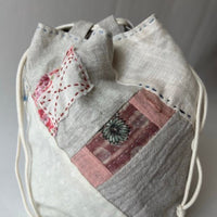 Drawstring bag with patchwork design on a gray background