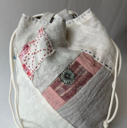 Drawstring bag with patchwork design on a gray background