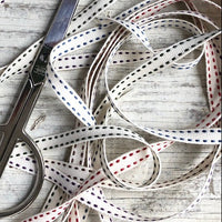 Scissors and ribbons on a wooden surface
