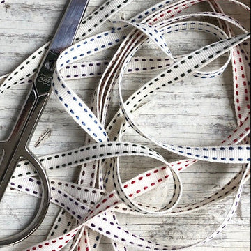 Scissors and ribbons on a wooden surface