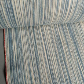 Roll of blue and white striped fabric on a gray surface