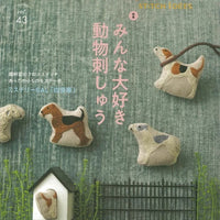 Cover of a magazine featuring animal-themed needlework on a green background