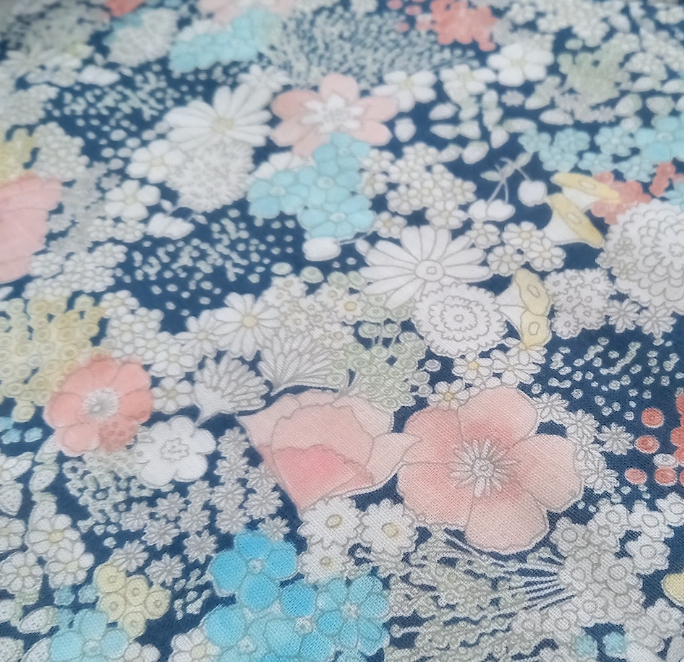 Floral fabric pattern with pink, blue, and white flowers on a dark blue background