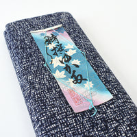 Blue and white patterned fabric with a decorative tag on a white background