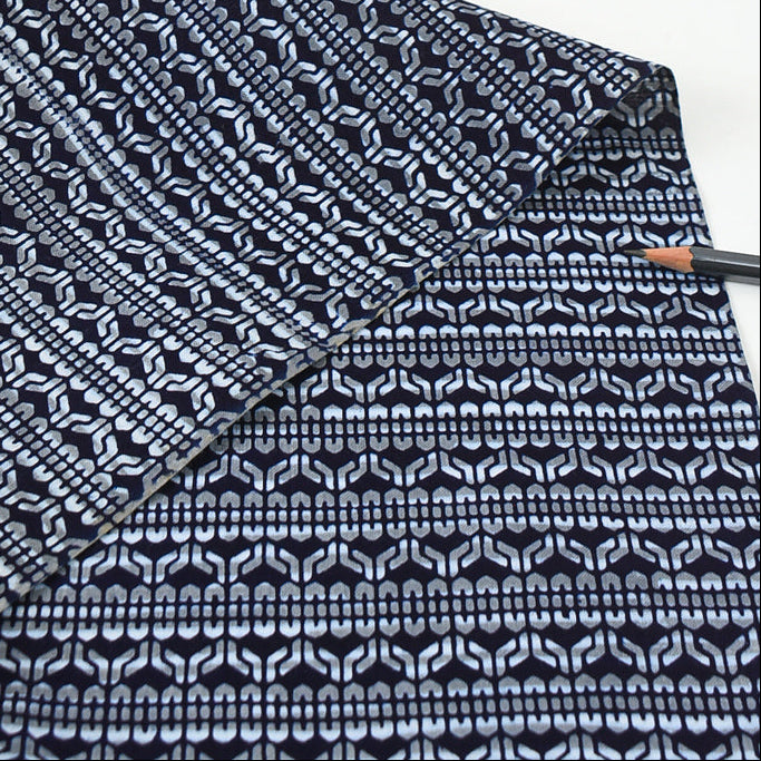 Close-up of a folded fabric with a black and white pattern on a white background