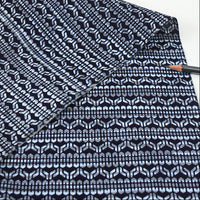 Close-up of a folded fabric with a black and white pattern on a white background