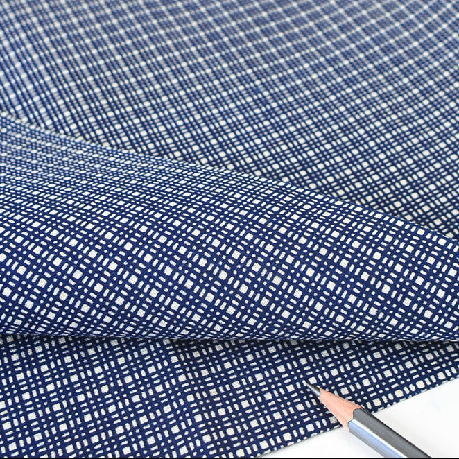 Blue checkered fabric with a pencil on a white background