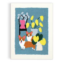Framed woven art piece with two corgis and flowers on a blue background