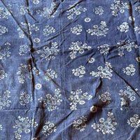Blue fabric with white floral patterns on a wooden surface