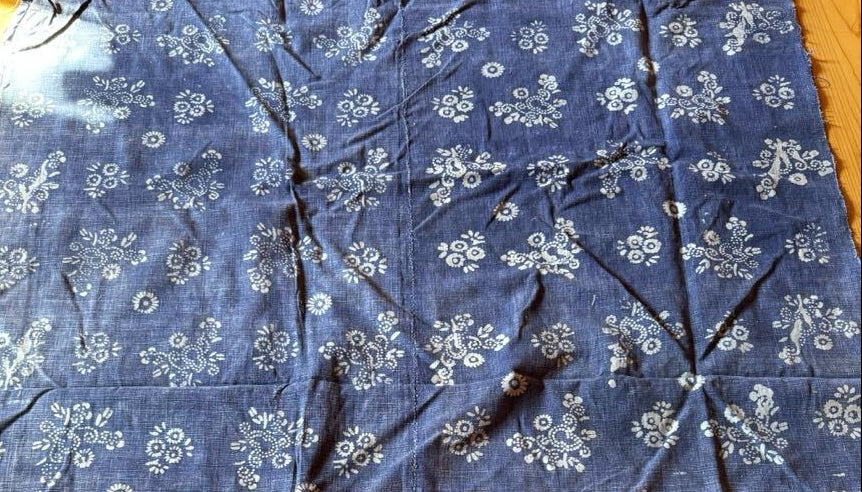 Blue fabric with white floral patterns on a wooden surface