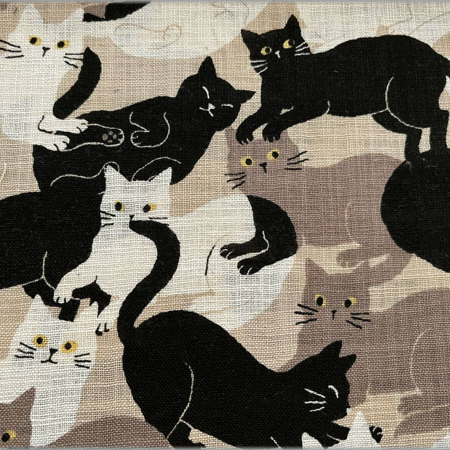 Pattern of black and white cats on a beige background