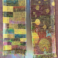 Colorful woven scarf on a wooden hanger against a textured brown background
