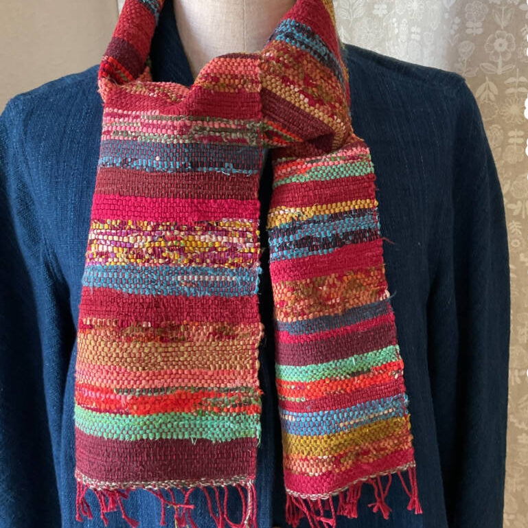 Colorful striped scarf on a mannequin with a plain background