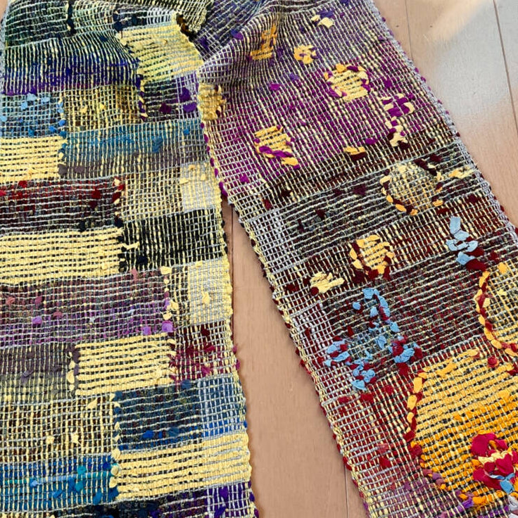 Colorful woven scarf with patterns on a plain background