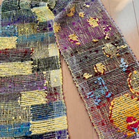 Colorful woven scarf with patterns on a plain background