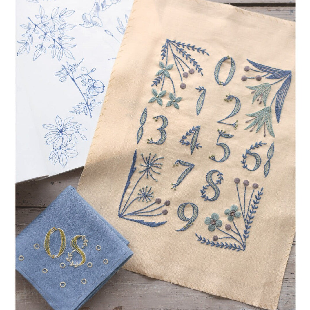 Embroidered fabric with numbers and floral patterns on a wooden surface