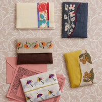 Collection of fabric pouches with various designs on a patterned background