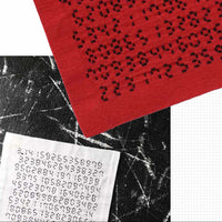 Red fabric with black pattern, black and white textured background, and white paper with black text.