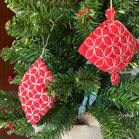 Red and white geometric-patterned ornaments on a Christmas tree.