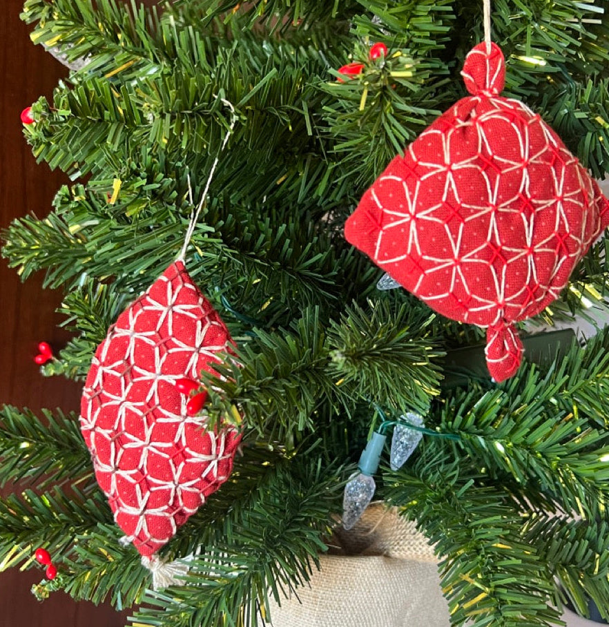 Red and white geometric-patterned ornaments on a Christmas tree.