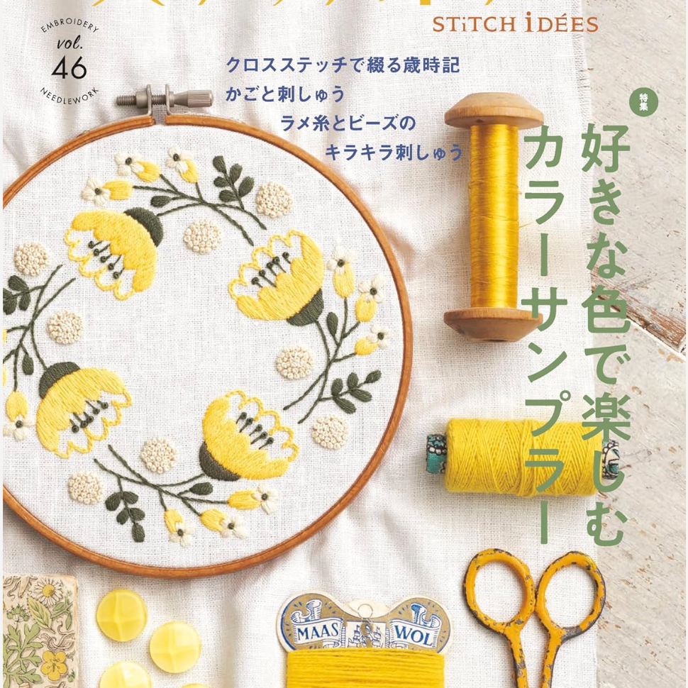 Embroidery book cover with cross-stitch design, yarn, scissors, and decorative elements.