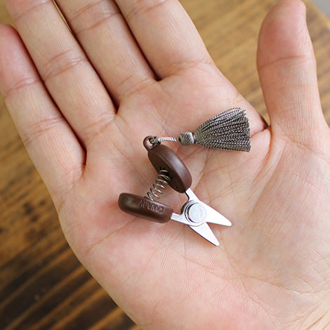 Cohana mini scissors snips with gray tassel in hand
